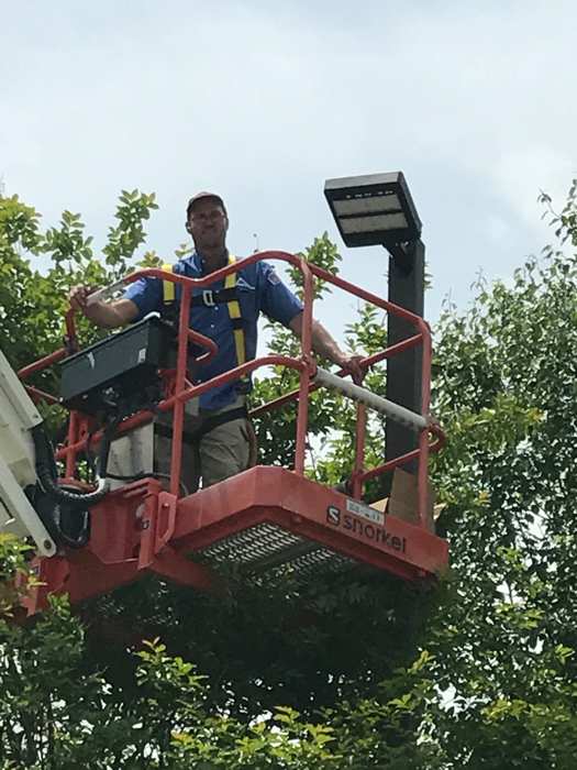 Elevated commercial lighting work completed safely with proper equipment.